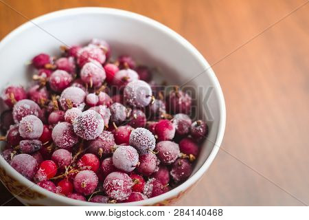 A Mixture Of Red Frozen Berries Of Currant And Gooseberry Covered With White Frost In A White Plate 