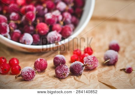 Red Frozen Berries Of Currant And Gooseberry, Covered With White Frost, In A White Plate And On The 