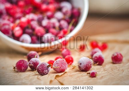 Red Frozen Berries Of Currant And Gooseberry, Covered With White Frost, In A White Plate And On The 