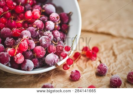 Red Frozen Berries Of Currant And Gooseberry, Covered With White Frost, In A White Plate And On The 
