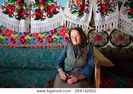 Muntele Bocului, Romania - February 7, 2019: Old rural woman called Lele Maria and her beautiful handworks. Romanian rural environment.