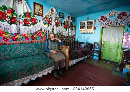 Muntele Bocului, Romania - February 7, 2019: Old rural woman called Lele Maria and her beautiful handworks. Romanian rural environment.