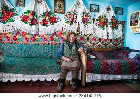 Muntele Bocului, Romania - February 7, 2019: Old rural woman called Lele Maria and her beautiful handworks. Romanian rural environment.