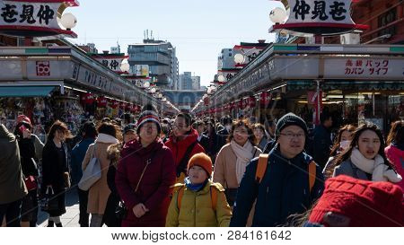 Crowds Of Tourists And Locals Walk And Shop Along Nakamise Dori Shopping Street By Sensoji Shrine In