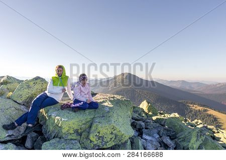 Mom And Daughter On The Top Of The Mountain. Woman And Baby On The Stone.