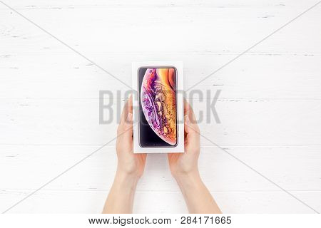 Berlin, Germany - December 09, 2018: Woman Hands Holding The Colorful Box Of The Latest Apple Iphone