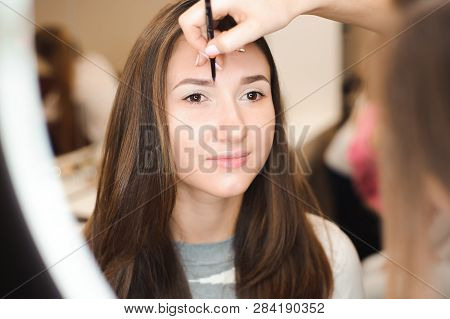 Make Up Artist Doing Professional Make Up Of Young Woman.