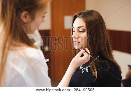 Make Up Artist Doing Professional Make Up Of Young Woman.
