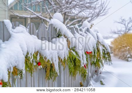 Winter Scenery With A Garland Draped On A Fence