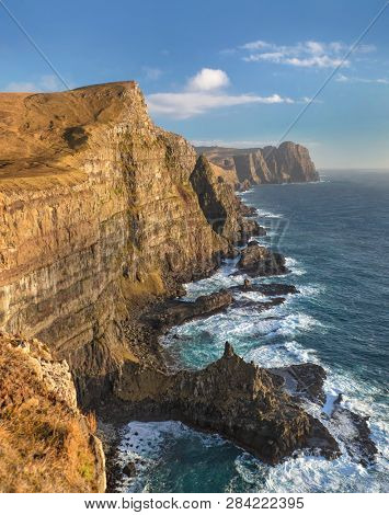 View along the southern coastline of the cliffs and crashing waves on the island of Suduroy in the Faroe Islands.