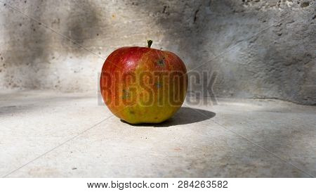 An Apple With A Shadow In Background