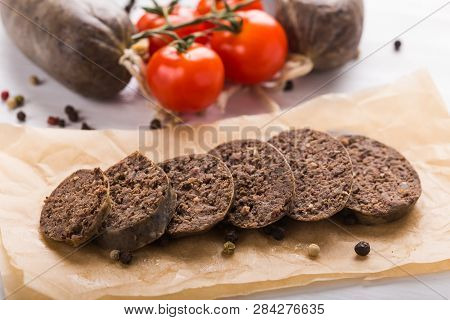 Food, Cuisine And Horsemeat Concept - Close Up Of Meat Sausage With Tomatoes And Pepper On Kraft Pap