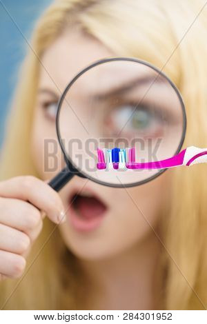 Beautiful Perfectionist Young Woman Checking Her Tooth Brush Through Manifying Loupe Glass. Hygiene,