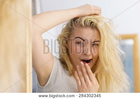 Young Blonde Female Feeling Dull And Tired After Waking Up. Woman Yawning Being Sleepy In Bathroom.