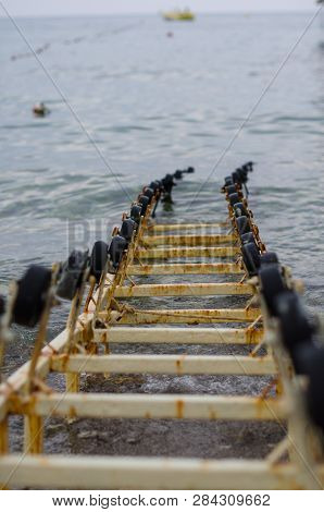 Rails Go Under The Water Of A Large Lake. Rails For Launching Yachts