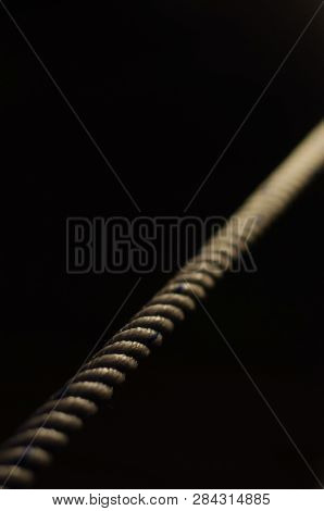 Straight Rope On A Black Background Is Illuminated With Light