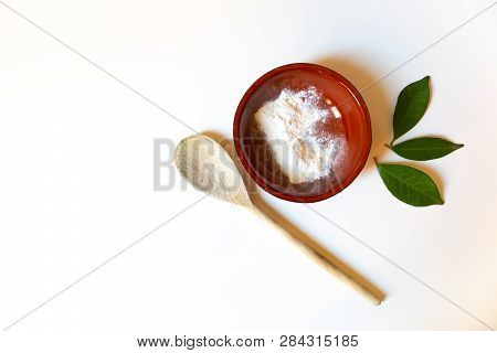 Homemade Face Mask With The White Clay, Wooden Spoon And Green Leaves Composition. Skincare Concept