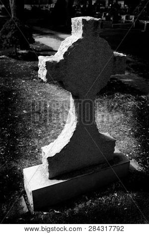 Gravestone cross in cemetery representing death marker grave stone