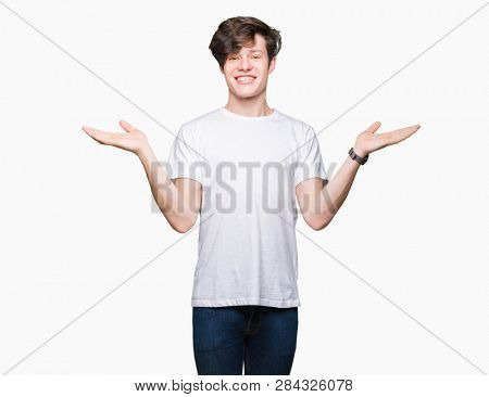 Young handsome man wearing casual white t-shirt over isolated background Smiling showing both hands open palms, presenting and advertising comparison and balance
