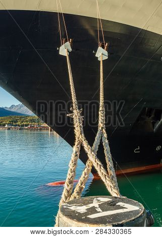 Mooring Lines And Rat Guards Tied At Bow Of Cruise Ship And Dock Bollard In Alaskan Deepwater Termin