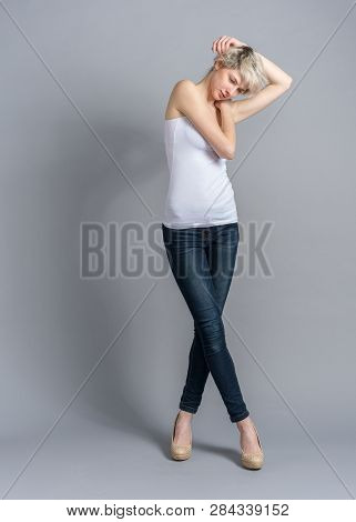 Model Snap In Casual Outfit, Melancholic Pose And Bent Arms Near Head. Woman With Short Hair, Studio