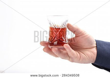Glass Turkish Armud With Tea In Male Hand On A White Background.