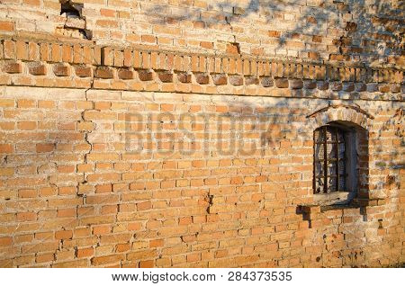 Brick Wall With A Window Illuminated By The Sun