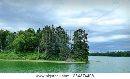 Natural Undeveloped Forest Lakeshore In Northern Minnesota On A Cloudy Day.