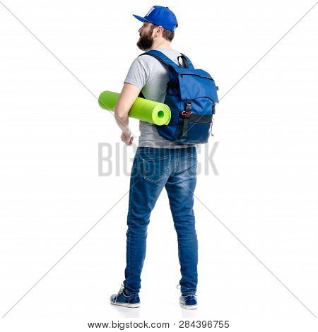 A Man Tourist In Jeans And Cap, Blue Backpack Karemat Standing Looking On White Background Isolation