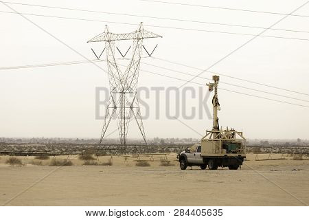 Border Patrol Surveillance Vehicel With Mexico And Barrier Wall In The Background