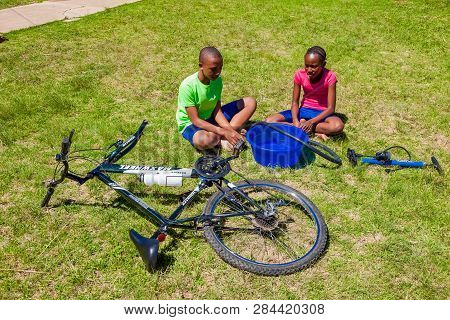 African Children Fixing A Puncture On A Bike