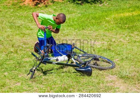 African Children Fixing A Puncture On A Bike