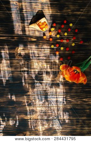 Tulips With Sweets In A Waffle Horn On A Wooden Background.