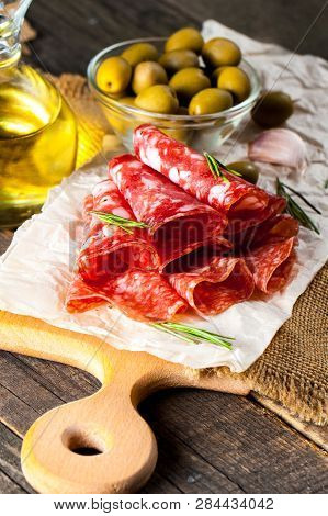 Italian Salami With Olives And Spices On Wooden Background