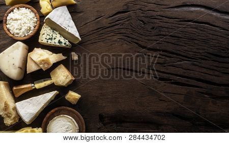 Assortment of different cheese types on wooden background. Top view.