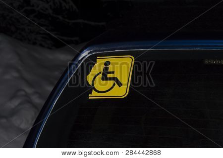 Striped Invalid Sticker On A Blue Car In The Winter Evening