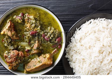 Persian National Food Meat Stew With Herbs And Beans Close-up In A Bowl Served With Steam Rice. Hori