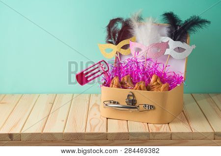 Jewish Holiday Purim Background With Suitcase Box, Carnival Mask, Noisemaker And Hamantaschen Cookie