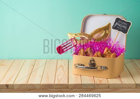 Jewish Holiday Purim Background With Suitcase Box, Carnival Mask, Noisemaker And Hamantaschen Cookie