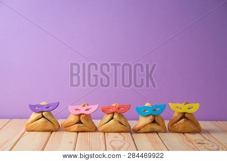 Jewish Holiday Purim Background With Cute Funny Hamantaschen Cookies On Wooden Table.