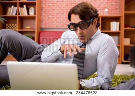 Young employee with virtual glasses during break in the office