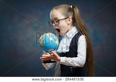 Amazed Little Blond Schoolgirl Look At World Globe. Primary School Student Study Geography. Suprised
