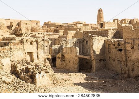 Ruins Of Ancient Arab Middle Eastern Old Town Built Of Mud Bricks, Old Mosque With Minaret. Al Qasr,