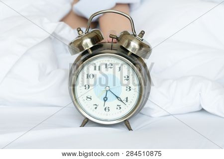 Alarm Clock Silver Style Vintage Place On A Bed With Hands Of Woman Holding A Clock. Retro Analog Wa