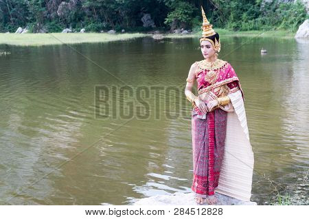Portrait Young Woman Wearing Traditional Thai Red And Purple And Gold Jewelry In The Water Park. Bea