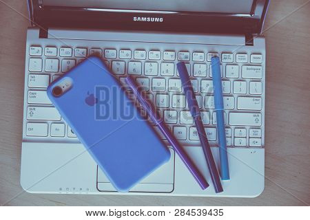 Laptop Kayboard And Apple Cellphone On The Desk. Urban Home Design Photo.