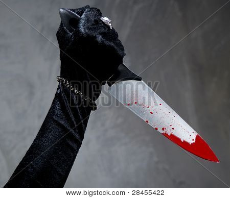 Mano femmina con coltello insanguinato