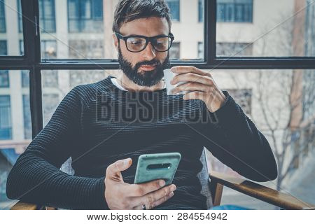 Bearded Hispanic Man In Black Pullover Using Mobile Phone Application For Mobile Blog. Confident You