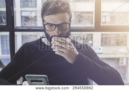 Bearded Hispanic Man In Black Pullover Using Mobile Phone Application For Mobile Blogging.confident 