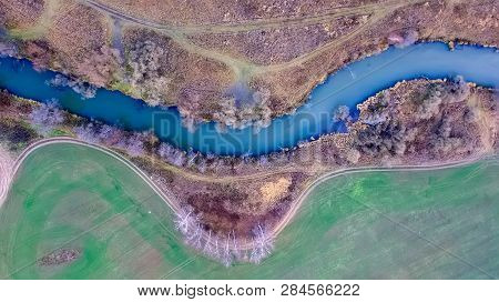 Top View Of The Bend Of The River In A Colorful Autumn Field